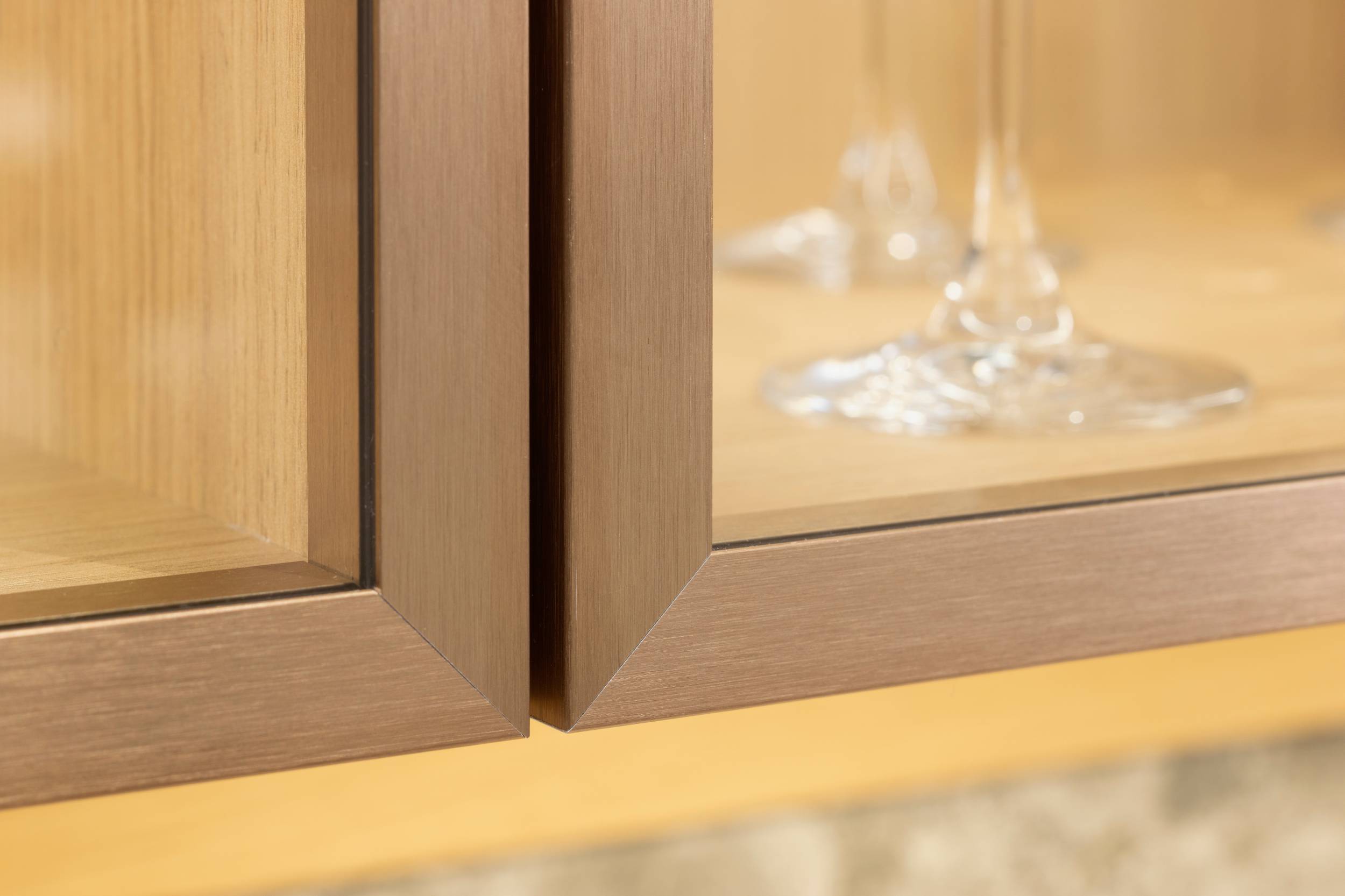 HÄCKER Systemat moderne Landhausküche Iseo Gris und Feineiche - Detailansicht Metallrahmen Glastüren der Vitrine, bronze