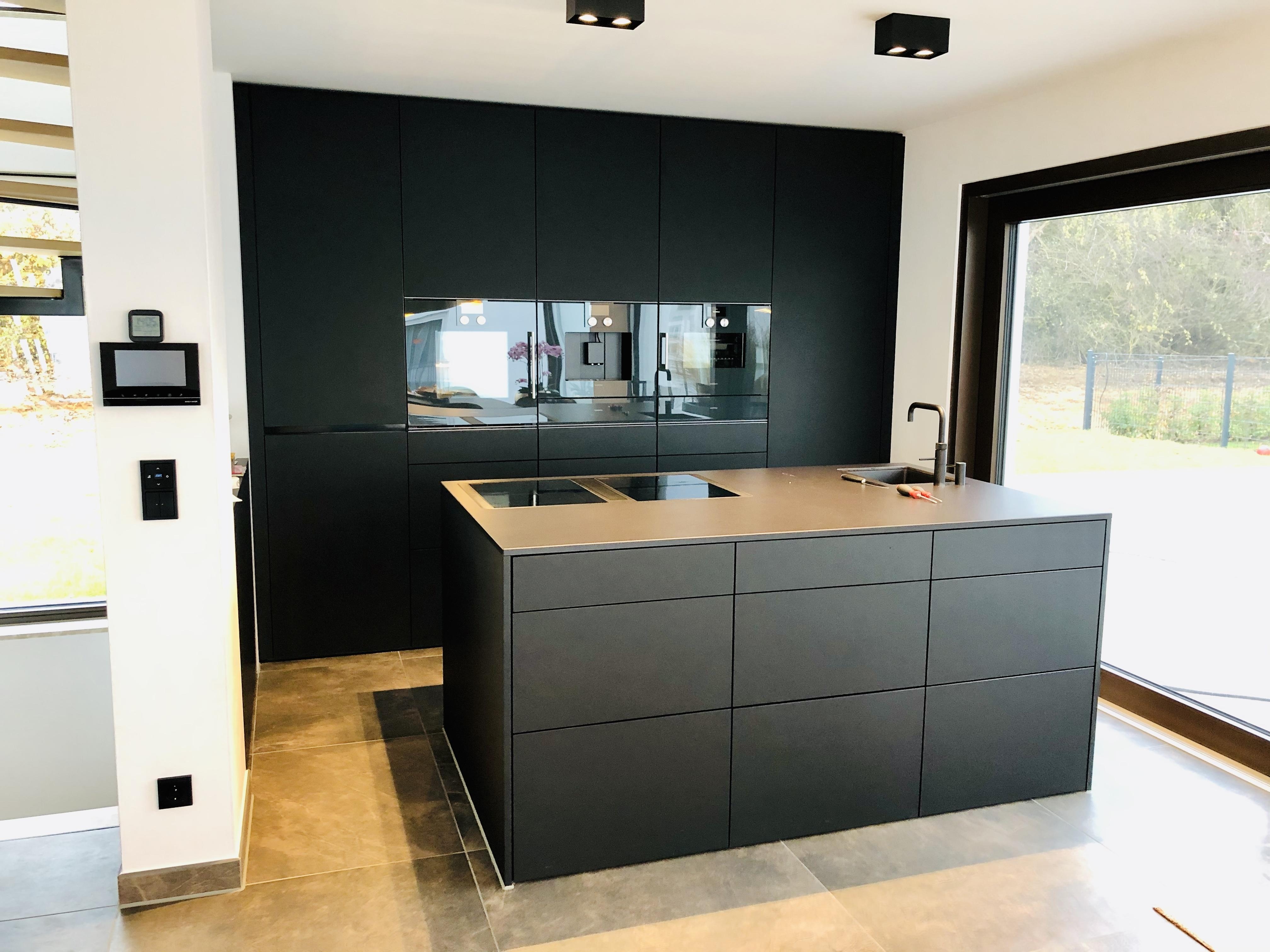 Push to open Küche mit Hochschrankzeile und Kücheninsel in schwarz