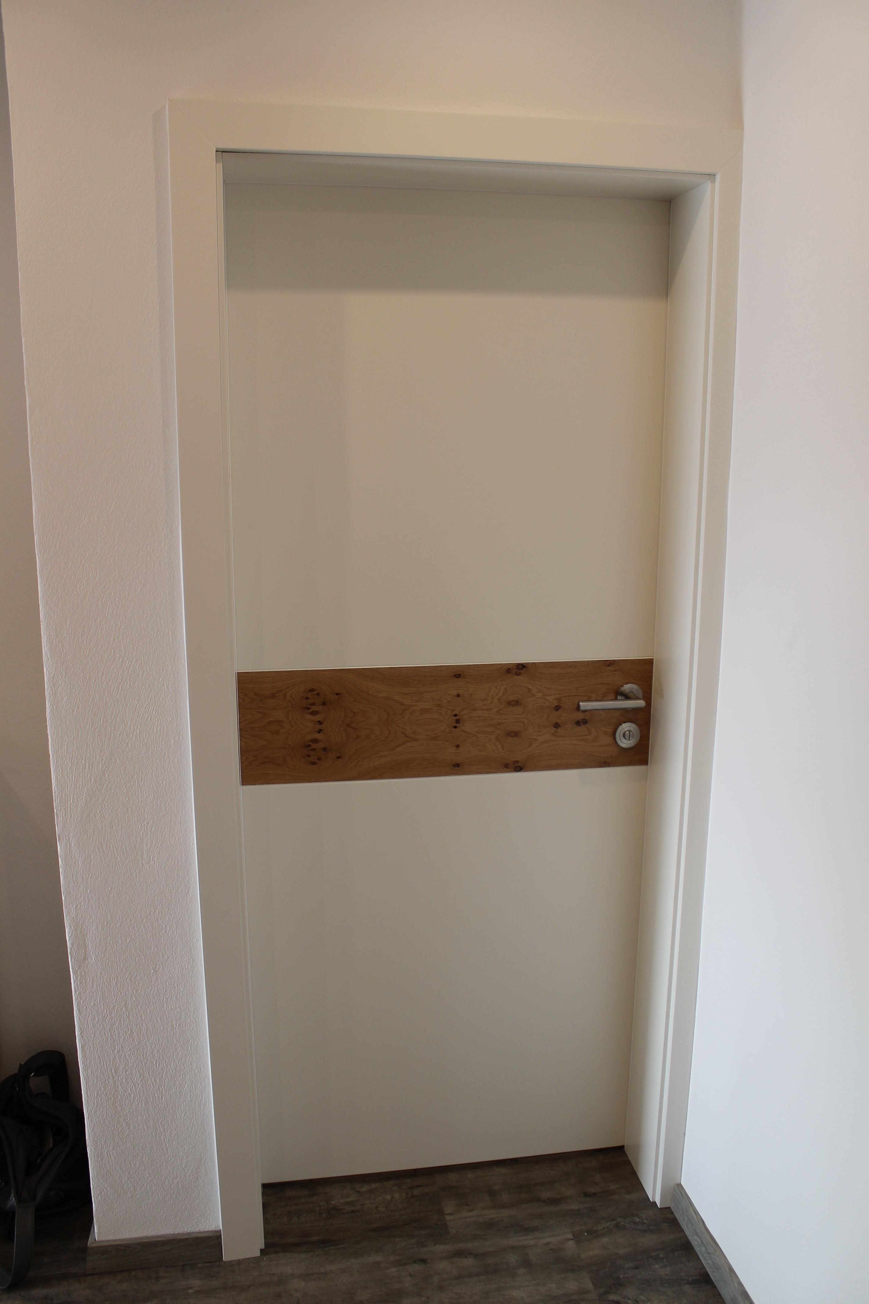 Weiße Innentür mit einem eingesetzten Holzstreifen