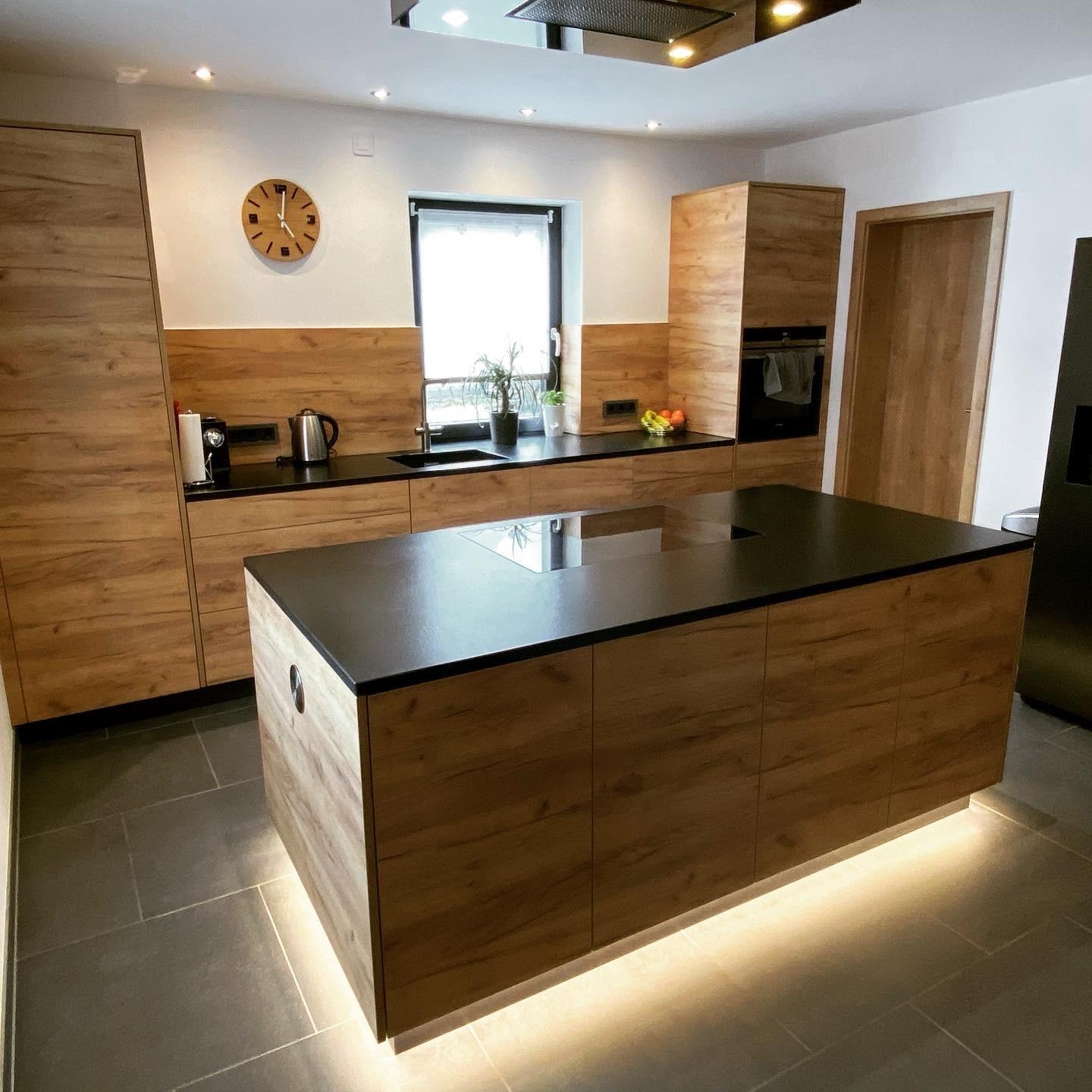 Holzküche mit Insel und Sockelbeleuchtung