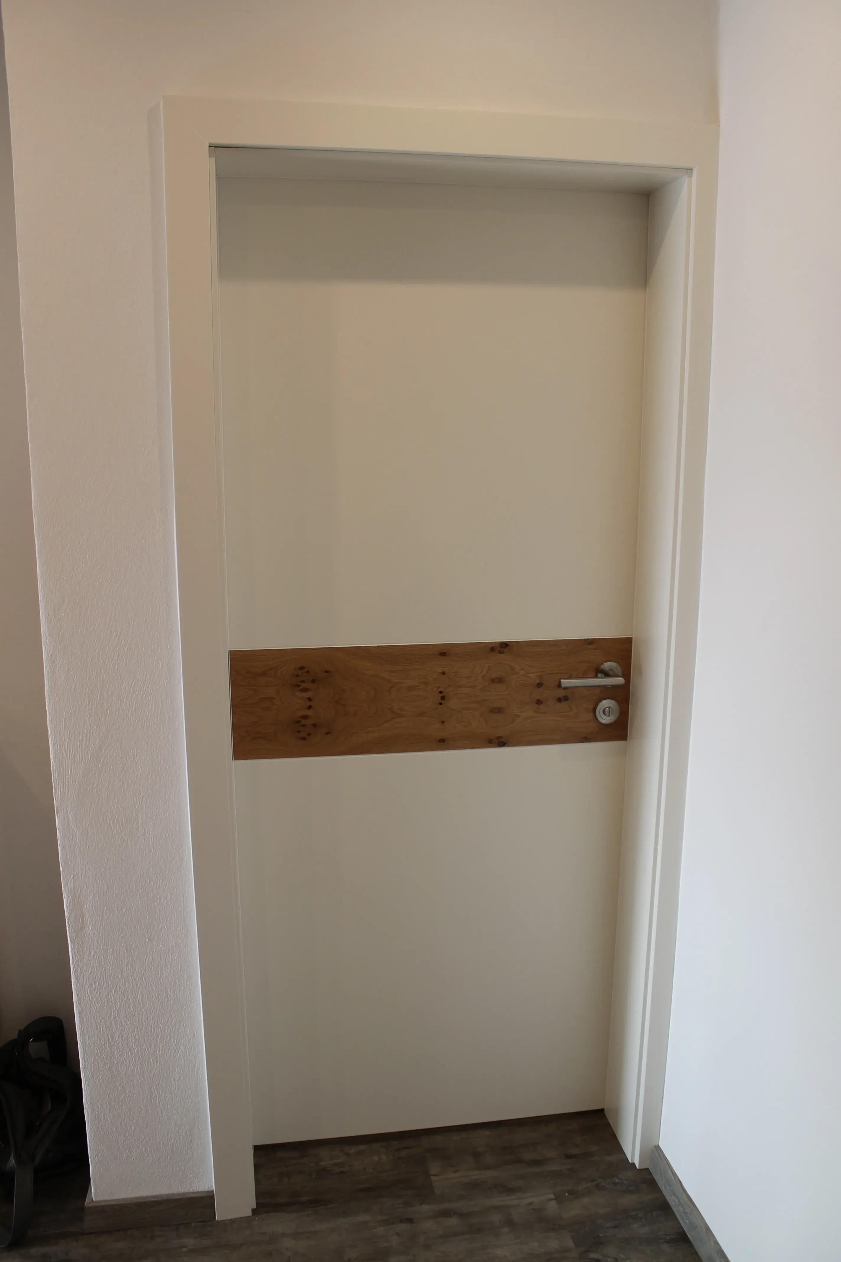 Weiße Innentür mit einem eingesetzten Holzstreifen